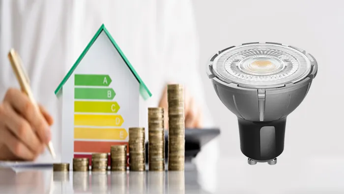 Energy-efficiency chart, stacked coins, and an LED spotlight representing cost savings and reduced power consumption