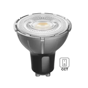 Close-up view of a modern GU10 LED spotlight bulb with a white plastic housing, emitting warm yellow light from its circular LED face, and labeled with CCT and power symbols.