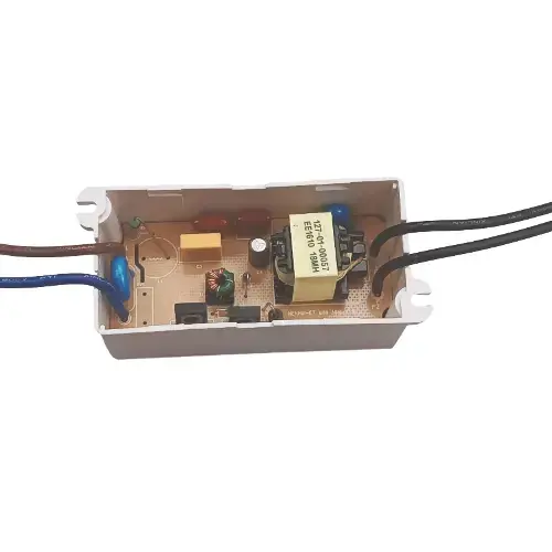 White plastic enclosure with an exposed internal circuit board featuring a yellow transformer, blue capacitors, resistors, and black and brown power wires.