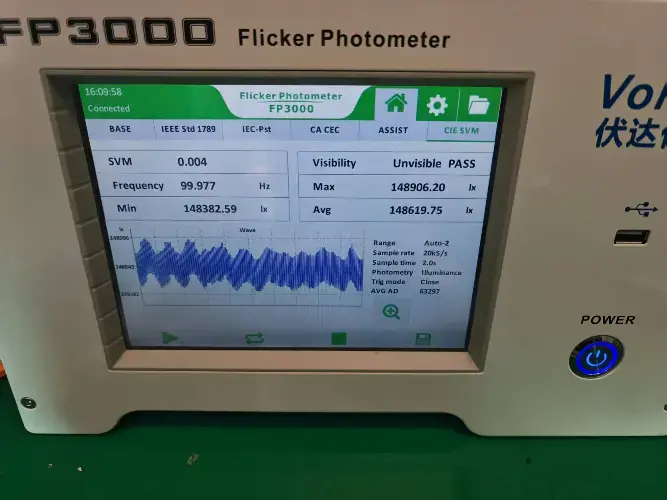 Digital screen of FP3000 Flicker Photometer displaying measurements including an SVM value of 0.157, minimum 95.77 Hz, maximum 148.60 Hz, and options for visible and invisible flicker analysis.