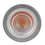 Close-up of a circular LED light bulb with frosted white glass cover and inner orange swirling concentric circles creating a hypnotic spiral pattern.
