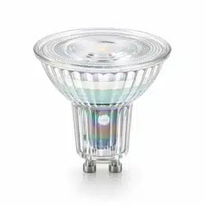 A transparent LED spotlight bulb with colorful iridescent reflections on its faceted glass surface and metal pins.