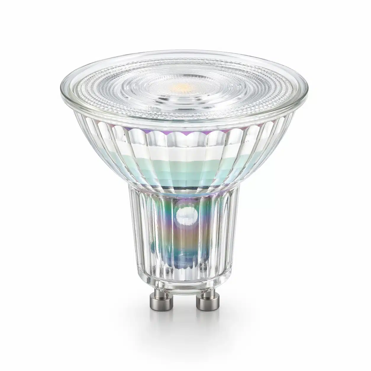 A transparent LED spotlight bulb with colorful iridescent reflections on its faceted glass surface and metal pins.