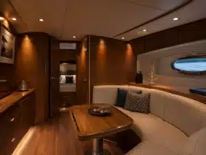 Modern yacht cabin interior with warm recessed LED lighting on wood surfaces.